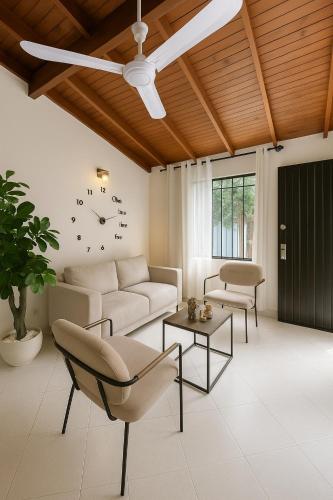 ein Wohnzimmer mit einer Couch und einer Uhr an der Wand in der Unterkunft Casa Bosques in Pilarica - Family and cozy in Medellín