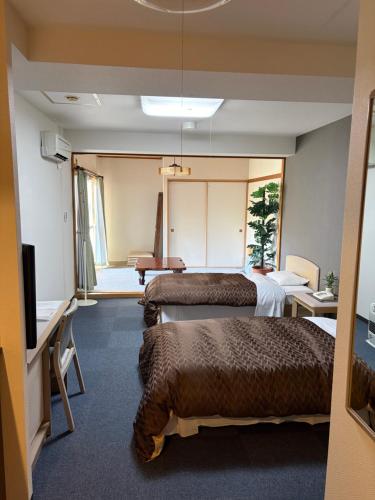 a hotel room with two beds and a flat screen tv at フューデイズコンドミニアム定山渓211号室(最大5名まで） in Jozankei