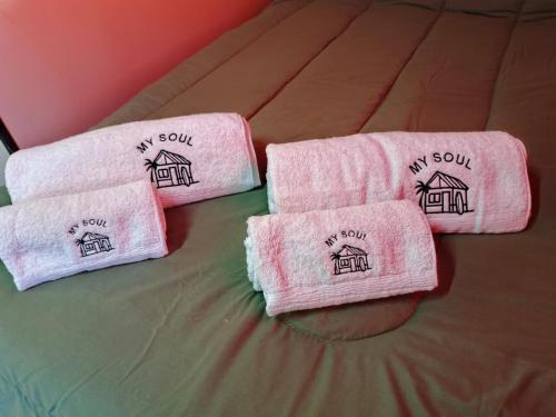 three towels sitting on top of a bed at My Soul in Camet Norte