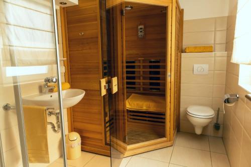 a bathroom with a shower and a toilet and a sink at Ferienhaus Rügentraum in Glowe