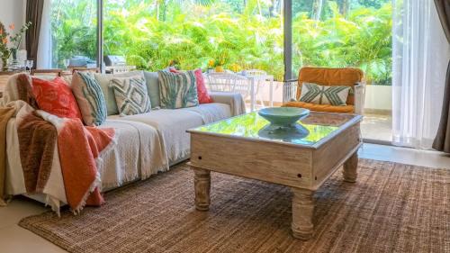 Una sala de estar con un sofá y una mesa de café. en Recently renovated 3BR apartment near Layan Beach, en Phuket