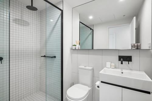 a bathroom with a shower and a toilet and a sink at Luxe High-Floor Retreat- Epic Views-Steps to Crown in Melbourne