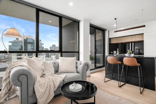 a living room with a couch and a table at Luxe High-Floor Retreat- Epic Views-Steps to Crown in Melbourne