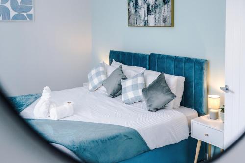a bedroom with a bed with blue and white pillows at 3BR House By Eason Stays Short Term Rental Wythenshawe Near Manchester Airport with Free Parking in Wythenshawe