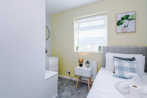 a bedroom with a white bed and a window at 3BR House By Eason Stays Short Term Rental Wythenshawe Near Manchester Airport with Free Parking in Wythenshawe