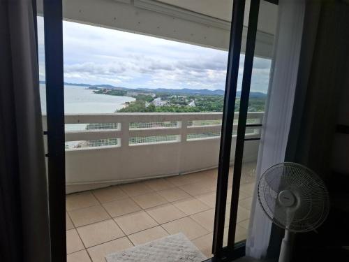 a balcony with a fan and a view of the water at Apartment on Beach, Stunning Views, Rayong in Ban Phayun