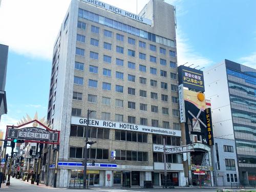 a tall building with a sign for green rich hotels at Green Rich Hotel Kagoshima Tenmonkan in Kagoshima