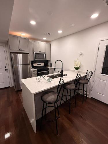 a kitchen with a white counter and a kitchen island with chairs at Bluehouse in East Chicago