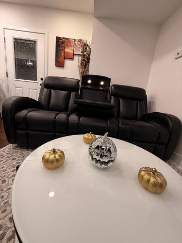 a living room with a white table and a black couch at Bluehouse in East Chicago