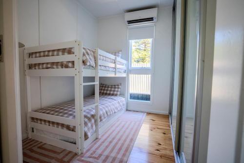 a bedroom with two bunk beds and a window at Coastal Escape 3BR 2BA Family Retreat in Sellicks Beach