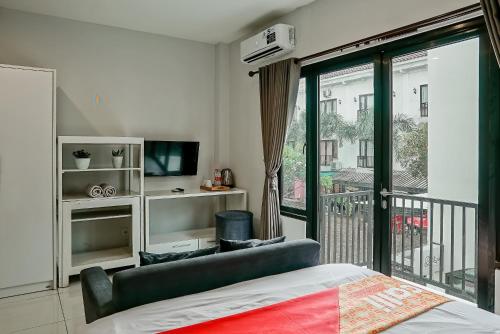 a bedroom with a bed and a balcony at Jember Town Square by Calli Rooms in Wirolegi
