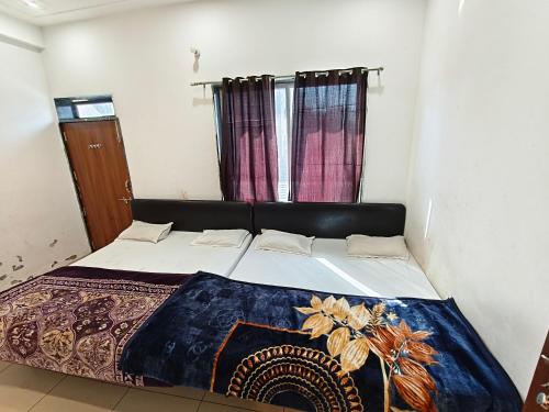 a bedroom with a large bed with a blanket on it at Aasha Palace Khatu Shyam Ji in Khātu