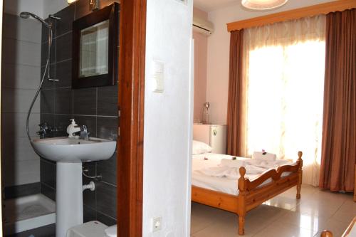 baño con lavabo y cama en Aiolos House, en Skiathos