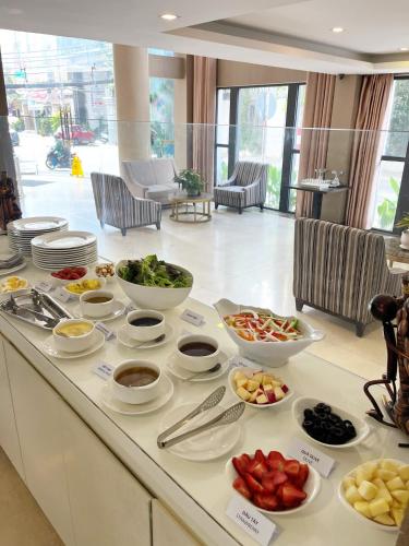 un bufé con cuencos y platos de comida en un mostrador en Ciao SaiGon Hotel & Spa, en Ho Chi Minh