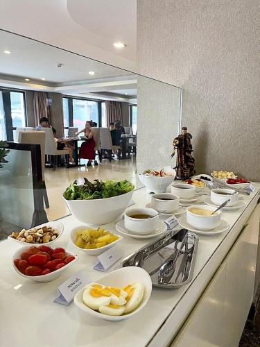 Un buffet con tazones de comida en una mesa. en Ciao SaiGon Hotel & Spa, en Ho Chi Minh