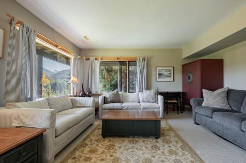 a living room with a couch and a table at Heron Chalet by Outpost Whistler in Whistler