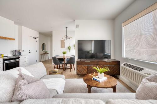 a living room with a couch and a tv at Stay Portland - City Serenity- Stylish 2-Bed Alberta Haven in Portland
