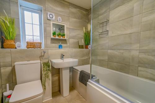 a bathroom with a sink and a toilet and a bath tub at 2 BR House By Eason Stays Short Lets & Serviced Accommodation Chester With Free Parking in Chester