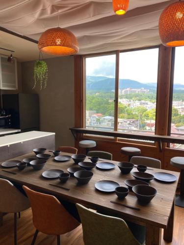 une table avec des bols dessus dans une pièce avec vue dans l'établissement 一棟貸し宿月灯草津, à Kusatsu