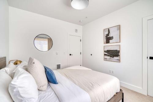 a white bedroom with a bed and a mirror at Stay Portland - Stylish Luxe Suite N Williams & Alberta Districts in Portland
