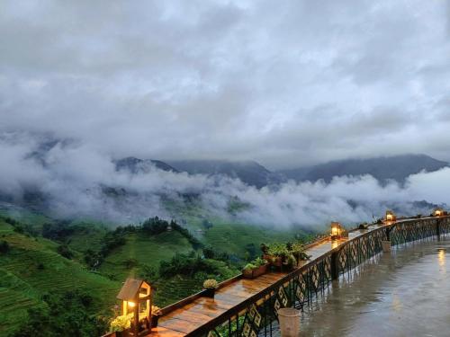 a balcony with a view of a mountain with clouds at Sapana Mountain Retreat in Sapa