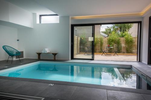 - une piscine au milieu d'une maison dans l'établissement Villa Pradelle et swimming pool, à Clermont-Ferrand