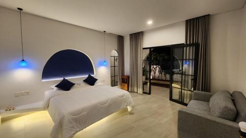 a bedroom with a bed and a couch at Bnaya Villas Riverside in Amed