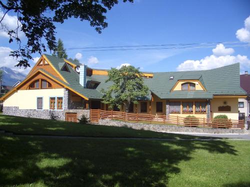 a large house with a green roof at Penzion u Pejtrika in Mengusovce