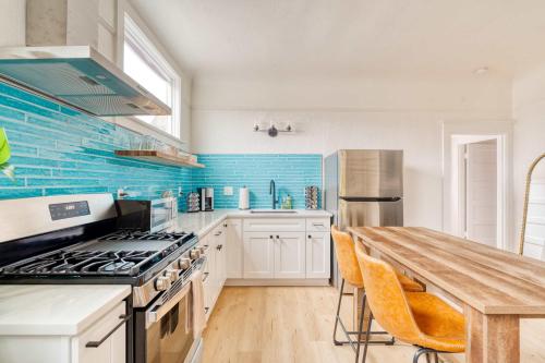 a kitchen with white cabinets and a wooden table at Stay Portland - The Garden Bungalow on Broadway - 94 WalkScore in Portland