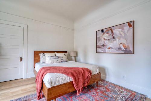 a bedroom with a bed and a painting on the wall at Stay Portland - The Sullivan's Gulch Lodge - 94 WalkScore in Portland
