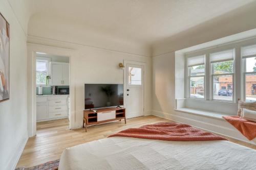 a large white room with a television and a kitchen at Stay Portland - The Sullivan's Gulch Lodge - 94 WalkScore in Portland