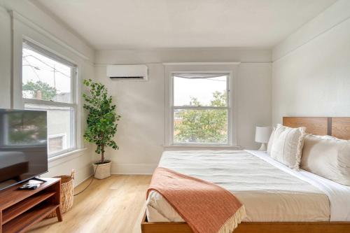 a bedroom with a large bed and two windows at Stay Portland - The Sullivan's Gulch Retreat - 94 Walk Score in Portland