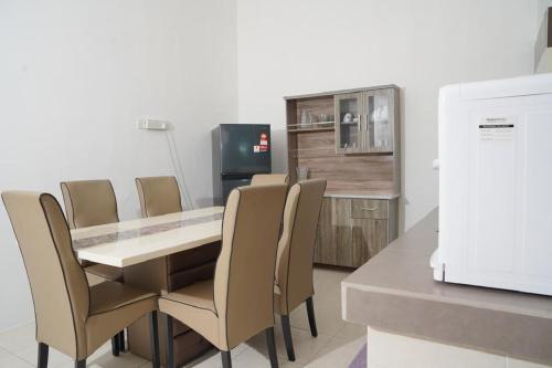 a dining room with a table and chairs and a refrigerator at Berkat Juta Homestay 2 in Kuantan