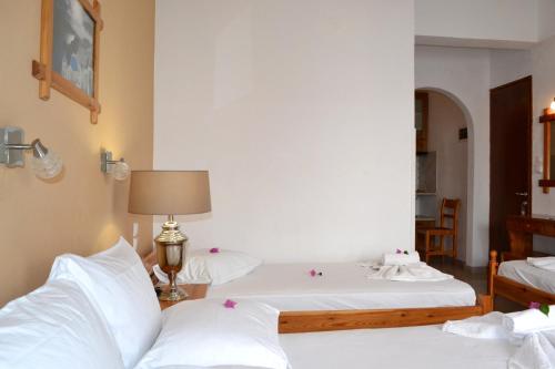 a bedroom with two beds with white sheets at Aiolos House in Skiathos Town