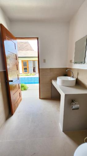 a bathroom with a sink and a toilet and a door at Panglao Ramyer Villa 2 in Sampong