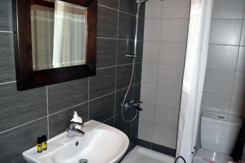a bathroom with a sink and a toilet and a mirror at Aiolos House in Skiathos Town