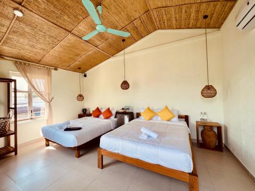 a bedroom with two beds and a ceiling fan at New Yêu Biển homestay in Vĩnh Hy