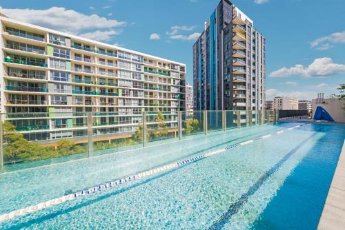 an empty swimming pool with buildings in the background at Gorgeous 3BR,2Parking,Pool,Gym,near Airport and City in Sydney
