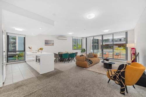 an open living room with a kitchen and a dining room at Gorgeous 3BR,2Parking,Pool,Gym,near Airport and City in Sydney