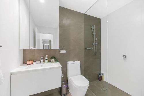 a bathroom with a toilet and a sink and a shower at Gorgeous 3BR,2Parking,Pool,Gym,near Airport and City in Sydney