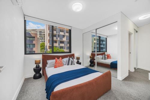 a bedroom with two beds and a large window at Gorgeous 3BR,2Parking,Pool,Gym,near Airport and City in Sydney