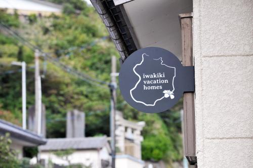 a sign hanging on the side of a building at iwakiki vacation homes 大型犬と泊まれる完全貸し切り貸別荘 in Iwaki