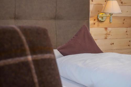 a bed with a pillow and a lamp in a room at Garni Lanzinger in Selva di Val Gardena