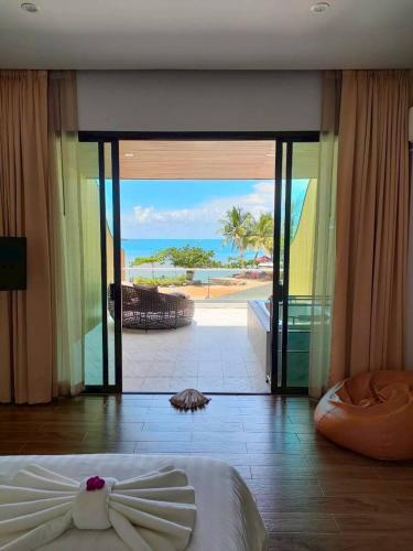 a bedroom with a view of the ocean from a resort at Kaibae Hut Resort in Ko Chang