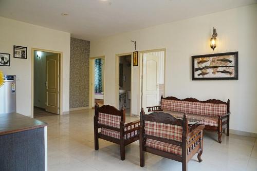 LāndrānにあるSparsha luxury- HomeStayの椅子2脚とテーブルのあるリビングルーム