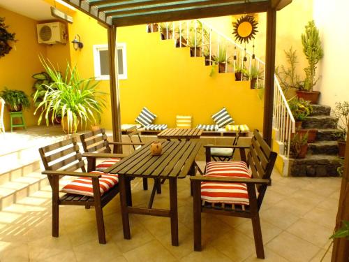 a patio with a wooden table and chairs at Kira's Boutique Hotel in Mindelo