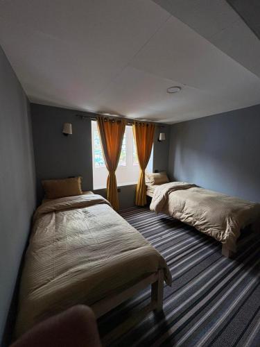 a bedroom with two beds and a window at Highcamp B&B in Namche