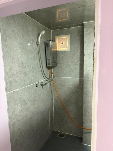 a shower with an orange cord attached to a wall at Highcamp B&B in Namche