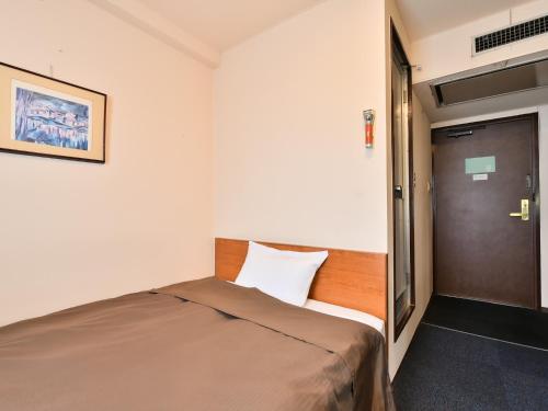 a small bedroom with a bed and a door at Suzuka Royal Hotel - Vacation STAY 38899v in Suzuka