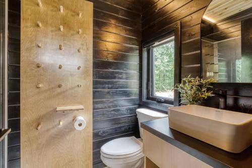 a bathroom with a sink and a toilet and a window at Smoky Nook Soak and Smores Getaway in Cosby